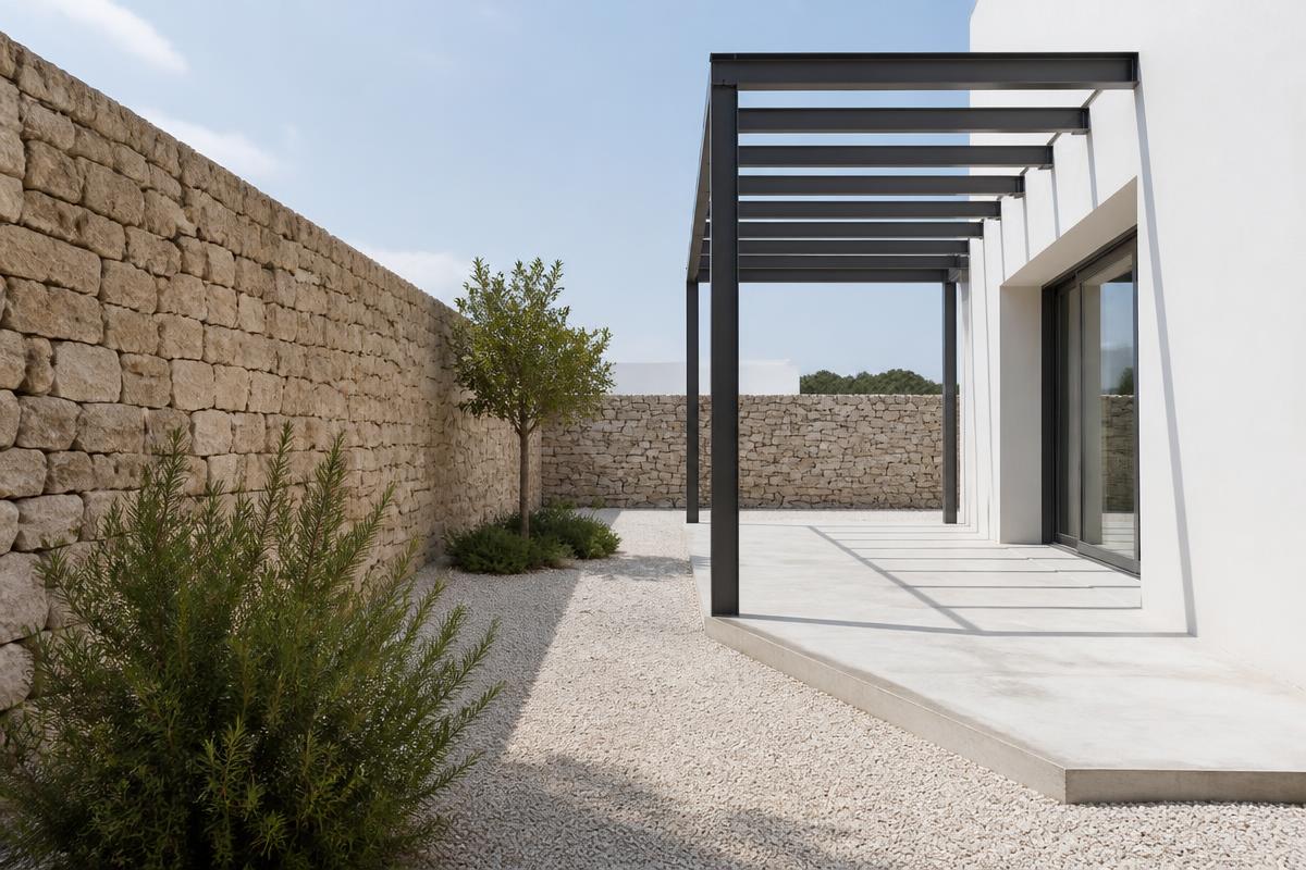 Courtyard with dry-stone wall and black steel pergola
